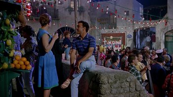 Movie still from “It Started in Naples” (1960), directed by Melville Shavelson – A man and a woman are sitting on a wall; Wide shot, Low angle