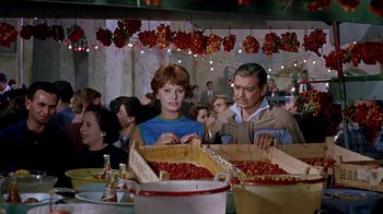 Movie still from “It Started in Naples” (1960), directed by Melville Shavelson – A man and a woman looking at a box of cherries; Medium shot, High angle