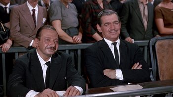 Movie still from “It Started in Naples” (1960), directed by Melville Shavelson – A couple of men sitting next to each other in suits; Medium shot, High angle