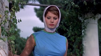 Movie still from “It Started in Naples” (1960), directed by Melville Shavelson – A woman wearing a blue shirt and a white bandage on her head; Close Up shot, Low angle
