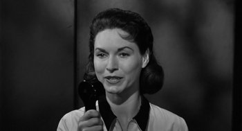 Movie still from “It! The Terror from Beyond Space” (1958), directed by Edward L. Cahn – An old photo of a woman holding a hair dryer; Close Up shot, Low angle