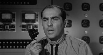 Movie still from “It! The Terror from Beyond Space” (1958), directed by Edward L. Cahn – A man holding a phone up to his ear; Close Up shot, Low angle