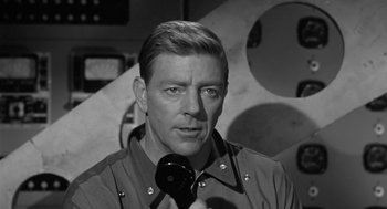 Movie still from “It! The Terror from Beyond Space” (1958), directed by Edward L. Cahn – Black and white photograph of a man with a microphone in his hand; Close Up shot, Low angle