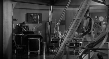 Movie still from “It! The Terror from Beyond Space” (1958), directed by Edward L. Cahn – An old photo of a room in a lab; Wide shot, Low angle