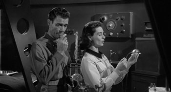 Movie still from “It! The Terror from Beyond Space” (1958), directed by Edward L. Cahn – A man and a woman standing next to each other; Medium shot, Low angle