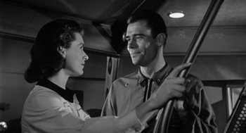 Movie still from “It! The Terror from Beyond Space” (1958), directed by Edward L. Cahn – A man and a woman are looking at each other in a car; Medium shot, Low angle