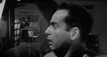 Movie still from “It! The Terror from Beyond Space” (1958), directed by Edward L. Cahn – A black - and - white photo of a man looking up; Close Up shot, Low angle