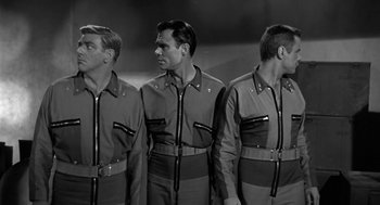 Movie still from “It! The Terror from Beyond Space” (1958), directed by Edward L. Cahn – A group of men standing next to each other in uniforms; Medium shot, Low angle