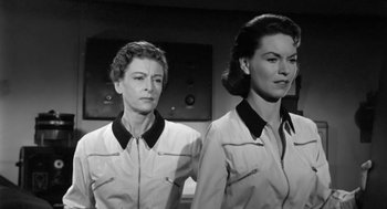 Movie still from “It! The Terror from Beyond Space” (1958), directed by Edward L. Cahn – A couple of women standing next to each other; Medium shot, Low angle