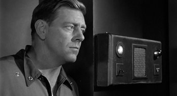 Movie still from “It! The Terror from Beyond Space” (1958), directed by Edward L. Cahn – A black and white photo of a man looking into a camera; Close Up shot, Low angle