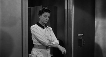 Movie still from “It! The Terror from Beyond Space” (1958), directed by Edward L. Cahn – A woman standing in front of an elevator; Medium shot, Low angle