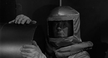 Movie still from “It! The Terror from Beyond Space” (1958), directed by Edward L. Cahn – A man wearing a suit and a helmet; Close Up shot, Low angle