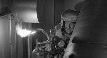 Movie still from “It! The Terror from Beyond Space” (1958), directed by Edward L. Cahn – A man wearing a helmet is looking at the camera; Medium shot, Low angle