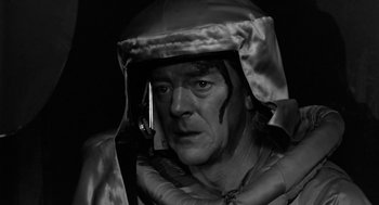 Movie still from “It! The Terror from Beyond Space” (1958), directed by Edward L. Cahn – A black and white photo of a man wearing a helmet; Close Up shot, Low angle