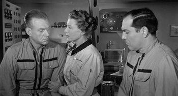 Movie still from “It! The Terror from Beyond Space” (1958), directed by Edward L. Cahn – A group of men standing next to each other; Medium shot, Low angle