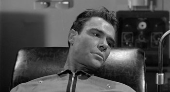 Movie still from “It! The Terror from Beyond Space” (1958), directed by Edward L. Cahn – Black and white photograph of a man in a leather jacket; Close Up shot, Low angle