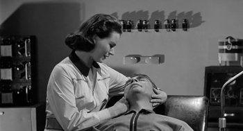 Movie still from “It! The Terror from Beyond Space” (1958), directed by Edward L. Cahn – A man and a woman are looking into each others eyes; Close Up shot, Low angle