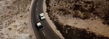 Movie still from “It's a Mad Mad Mad Mad World” (1963), directed by Stanley Kramer – A couple of cars driving down a street; Extreme Wide shot, Overhead angle