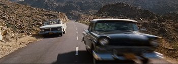 Movie still from “It's a Mad Mad Mad Mad World” (1963), directed by Stanley Kramer – A couple of cars driving down a street; Wide shot, High angle