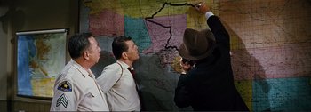 Movie still from “It's a Mad Mad Mad Mad World” (1963), directed by Stanley Kramer – A group of people standing around a map; Medium shot, High angle