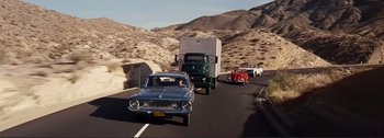 Movie still from “It's a Mad Mad Mad Mad World” (1963), directed by Stanley Kramer – A car and a truck on a road with mountains in the background; Wide shot, High angle