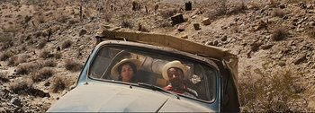 Movie still from “It's a Mad Mad Mad Mad World” (1963), directed by Stanley Kramer – A man and a woman sitting in the back seat of a car; Medium shot, High angle