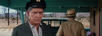 Movie still from “It's a Mad Mad Mad Mad World” (1963), directed by Stanley Kramer – A man wearing a hat and a jacket in front of another man; Close Up shot, Over the shoulder angle