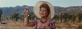 Movie still from “It's a Mad Mad Mad Mad World” (1963), directed by Stanley Kramer – An older woman wearing a straw hat holding a necklace; Close Up shot, High angle