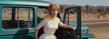 Movie still from “It's a Mad Mad Mad Mad World” (1963), directed by Stanley Kramer – A woman standing next to a car on a road; Medium shot, Low angle