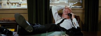Movie still from “It's a Mad Mad Mad Mad World” (1963), directed by Stanley Kramer – An older man in a white shirt and black tie; Medium shot, High angle