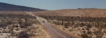 Movie still from “It's a Mad Mad Mad Mad World” (1963), directed by Stanley Kramer – A car driving down the middle of a desert road; Extreme Wide shot, High angle