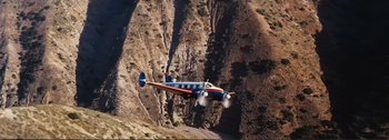 Movie still from “It's a Mad Mad Mad Mad World” (1963), directed by Stanley Kramer – An airplane is flying over a mountain side; Extreme Wide shot, Overhead angle