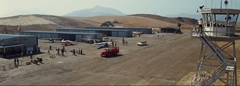 Movie still from “It's a Mad Mad Mad Mad World” (1963), directed by Stanley Kramer – An airport runway with a fire truck and airplanes parked; Extreme Wide shot, High angle