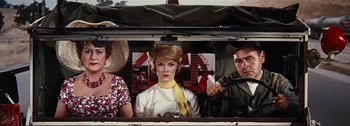 Movie still from “It's a Mad Mad Mad Mad World” (1963), directed by Stanley Kramer – A woman with a yellow ribbon sitting in the back of a truck; Medium shot, Low angle