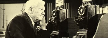 Movie still from “It's a Mad Mad Mad Mad World” (1963), directed by Stanley Kramer – An older man sitting in front of an old phone; Close Up shot, Low angle