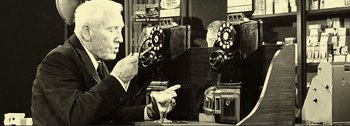 Movie still from “It's a Mad Mad Mad Mad World” (1963), directed by Stanley Kramer – An older man sitting in front of an old fashioned phone; Medium shot, High angle