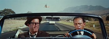Movie still from “It's a Mad Mad Mad Mad World” (1963), directed by Stanley Kramer – A man and a woman in the back seat of a car; Medium shot, Low angle