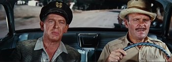 Movie still from “It's a Mad Mad Mad Mad World” (1963), directed by Stanley Kramer – A man and a woman sitting in the back seat of a car; Close Up shot, Over the shoulder angle