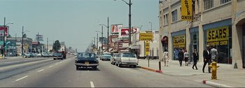 Movie still from “It's a Mad Mad Mad Mad World” (1963), directed by Stanley Kramer – A street scene with cars parked on the side of the road; Extreme Wide shot, High angle