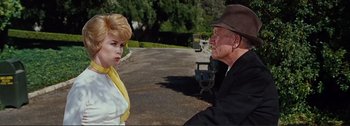 Movie still from “It's a Mad Mad Mad Mad World” (1963), directed by Stanley Kramer – An older man and a young woman talking on the side of the road; Medium shot, Low angle