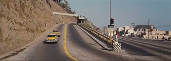Movie still from “It's a Mad Mad Mad Mad World” (1963), directed by Stanley Kramer – A road with a traffic light and a street sign; Extreme Wide shot, High angle