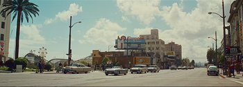 Movie still from “It's a Mad Mad Mad Mad World” (1963), directed by Stanley Kramer – Cars are driving down the street in a city; Extreme Wide shot, Low angle