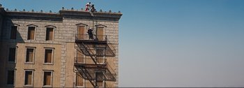 Movie still from “It's a Mad Mad Mad Mad World” (1963), directed by Stanley Kramer – A fire escape on the side of an old building; Extreme Wide shot, Low angle