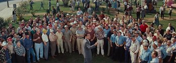 Movie still from “It's a Mad Mad Mad Mad World” (1963), directed by Stanley Kramer – A large group of men standing in front of a crowd; Wide shot, High angle