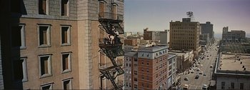 Movie still from “It's a Mad Mad Mad Mad World” (1963), directed by Stanley Kramer – Two men working on a fire escape on the side of a tall building; Extreme Wide shot, High angle