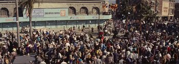 Movie still from “It's a Mad Mad Mad Mad World” (1963), directed by Stanley Kramer – A crowd of people sitting on the side of the street; Extreme Wide shot, High angle