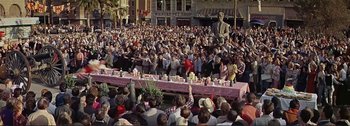 Movie still from “It's a Mad Mad Mad Mad World” (1963), directed by Stanley Kramer – A crowd of people sitting around a table with food on it; Extreme Wide shot, High angle