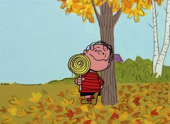 Movie still from “It's the Great Pumpkin, Charlie Brown” (1966), directed by Bill Melendez – Charlie brown holding a lollipop while standing in front of a tree; Extreme Wide shot, High angle