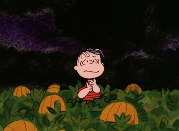 A charlie brown character is in a field of pumpkins
