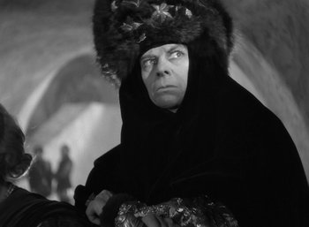 An older man wearing a black robe and a fur hat
